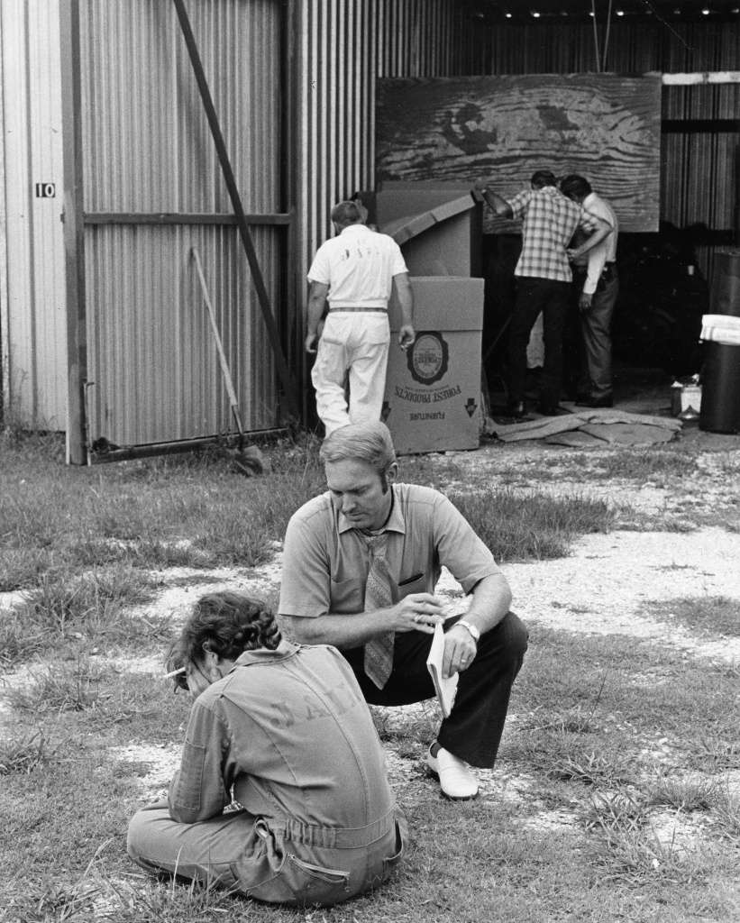 Wayne Henley, assis et les mains sur la tête, est interrogé par le détective Karl Siebeneicher devant le garage à bateaux. Photo : David Nance, Houston Chronicle.