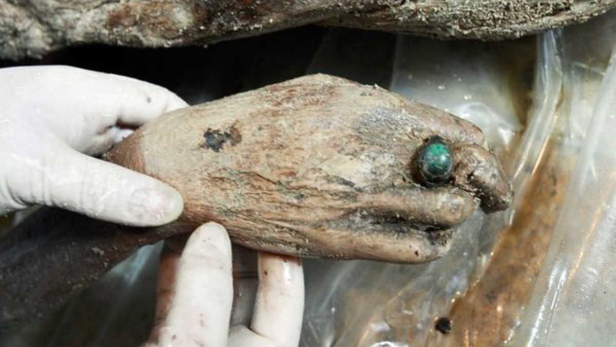 Un ouvrier du musée de Taizhou nettoie le grand anneau de jade de la momie humide chinoise, le 3 mars 2011. Le jade était associé à la longévité dans la Chine ancienne. Mais dans ce cas, l'anneau de jade était probablement un signe de sa richesse plutôt qu'un signe d'une quelconque préoccupation pour l'au-delà. Crédit image : Photographie de Gu Xiangzhong, Xinhua/Corbis