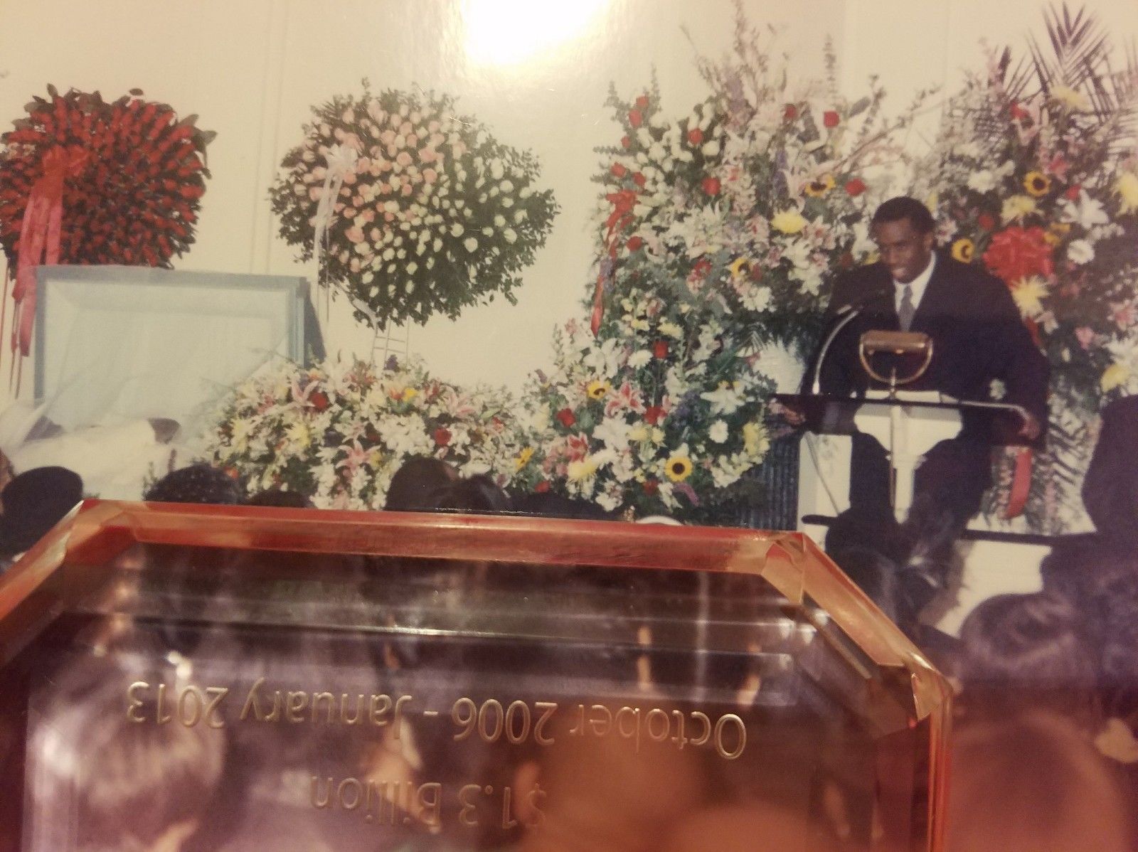 Puffy Combs prend la parole à la veillée funèbre de Notorious B.I.G. Sur la gauche de la photo, on peut voir le couvercle du cercueil ouvert. Notorious a été enterré vêtu de blanc et dans un cercueil blanc. Photo : The Coli Forum.
